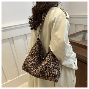 Vue détaillée du grand sac cabas imprimé léopard porté avec un trench-coat beige