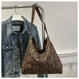 Vue détaillée du sac cabas à imprimé léopard suspendu devant une veste en jean
