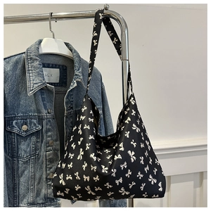 Gros plan d'un sac cabas en toile noire avec des motifs de nœuds blancs dessinés à la main