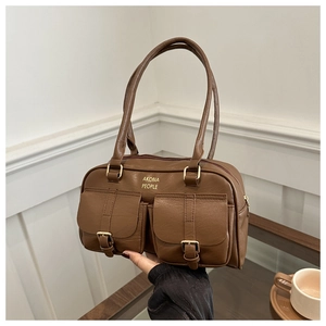Detail of vintage brown leather handbag with two buckle pockets and gold brand logo