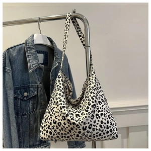 Grand sac cabas en toile à imprimé léopard suspendu à côté d'une veste en jean