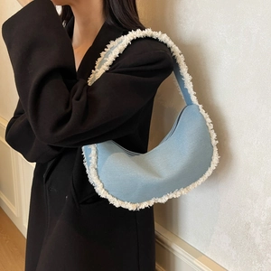 Sac hobo en jean bleu avec franges blanches et design minimaliste en forme de croissant