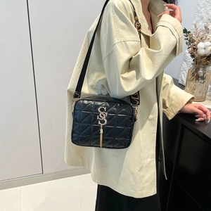 Black quilted crossbody bag with gold S-letter logo and patterned wide strap