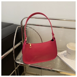 Detail of fuchsia crescent shoulder bag with smooth texture and golden zipper