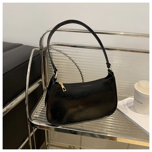 Detail of the high-quality black pleated leather texture and gold zipper on the shoulder bag