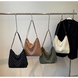 Detail of four distressed canvas tote bags in black, brown, green, and cream colors