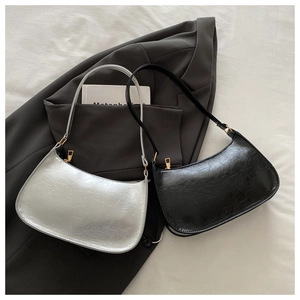 Detail of minimalist pleated leather shoulder bags in silver and black with gold zippers