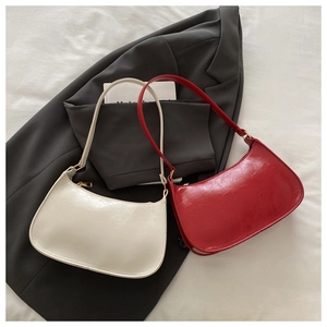 Close-up of vintage hobo bags in red and off-white with smooth oily leather texture