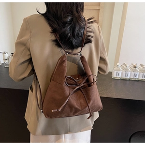 Detail eines dunkelbraunen Wildleder-Rucksacks mit elegantem Kordelzug und weicher Textur
