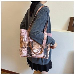 Side view of large tote bag featuring retro pink denim texture and brown leather strap