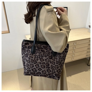 Dettaglio della borsa tote con stampa leopardata e manici in pelle nera indossata