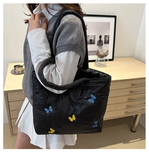 Detailansicht der blauen und gelben Schmetterlingsstickerei auf schwarzer Stepp-Tote-Bag