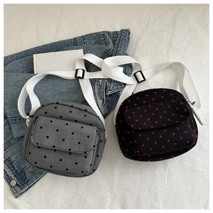 Flat lay of nylon crossbody bags with heart and polka dot prints on white background