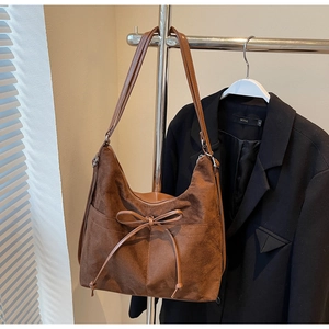 Detail der braunen Wildleder-Hobo-Tasche mit Schleifen-Kordelzug und Seitentaschen