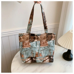 Detailed view of the large tote bag showing vintage denim print and leather patch accents
