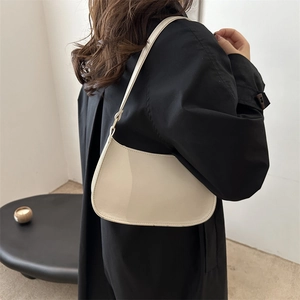 Minimalist beige moon hobo bag for women worn with a classic black trench coat
