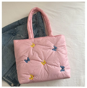 Detailaufnahme der rosa gesteppten Tragetasche mit bunten Schmetterlingsstickereien