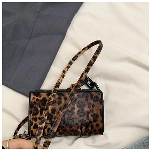 Detailed view of trendy leopard print crossbody bag with black decorative chain link