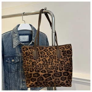 Dettaglio della borsa tote leopardata con manici in pelle marrone e trama in tela