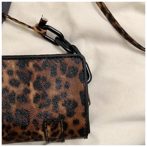 Detailed macro view of classic leopard print texture and black chain strap on square bag
