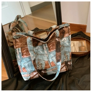 Detail of large tote bag with vintage denim pocket print and brown leather accents