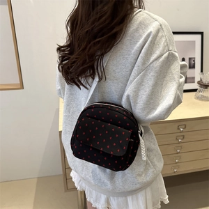 Black nylon shoulder bag with red heart pattern and adjustable white strap for women