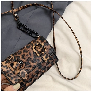 Close-up of leopard print crossbody bag featuring black resin chains and dual buckles