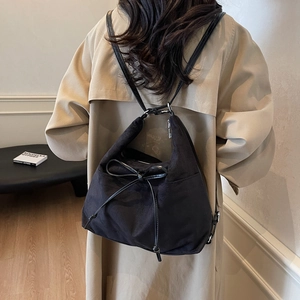 Minimalistische schwarze Kordelzugtasche mit Schleife, präsentiert von einem Model