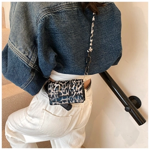 Detail of leopard print crossbody bag featuring black chain and textured strap for women