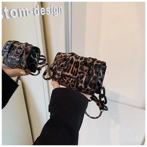 Detail of leopard print crossbody bag with dual buckles and black plastic chain strap