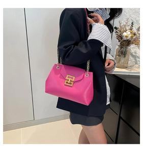 Detail of hot pink crossbody bag with gold chain strap and large geometric lock