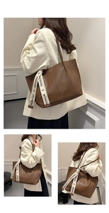 Detailed side view of brown leather tote bag featuring a decorative fashion ribbon detail