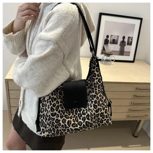 Chic leopard print tote bag with black leather flap worn by a model in a modern home setting