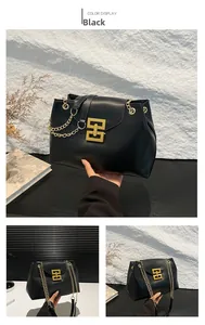 Detail of glossy black leather tote with a gold metal chain and iconic square clasp