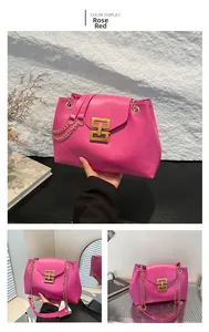 Detail of rose red tote bag featuring gold H-shaped buckle and metal chain strap