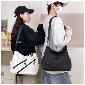 Detail view of large capacity crossbody tote bags in black and white with zipper accents