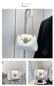 Detail of white tote bag with gold chain strap and geometric metal buckle on blazer