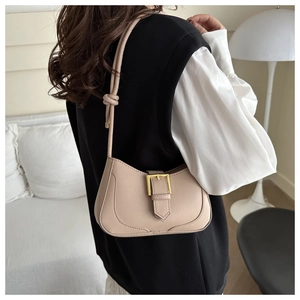 Détail du sac à bandoulière beige minimaliste avec boucle dorée et bandoulière nouée