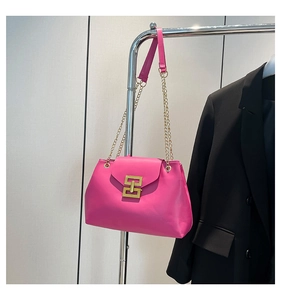 Pink faux leather tote bag with gold chain strap and geometric buckle on blazer background