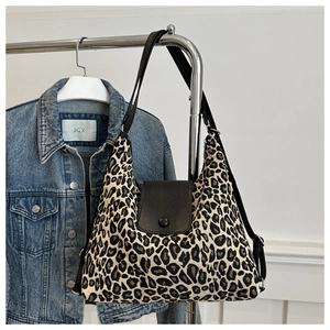 Detailed view of leopard print hobo bag with adjustable strap on a metal hanger