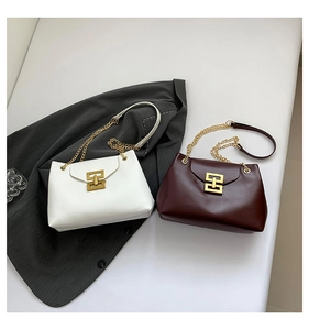 Detail of white and burgundy leather tote bags with gold hardware and chain straps