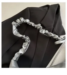 Vue détaillée d'une poignée plissée argentée sur un grand sac cabas vintage chic
