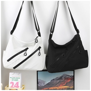 Dual crescent shoulder bags with parallel zippers and large ring pulls displayed on wall