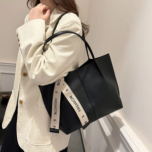 Large black leather tote bag with stylish letter ribbon detail for daily commuting