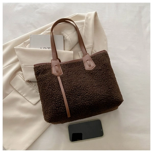 Flat lay of brown lamb wool tote bag with leather handles and lifestyle props