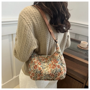 Detail of vintage floral jacquard shoulder bag featuring retro flower patterns on the fabric
