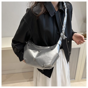 Vue détaillée du sac lune argenté avec papillons métalliques et bandoulière plissée chic