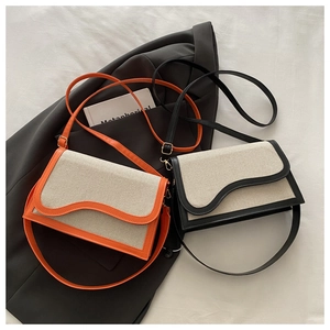 Detail of color-block flap crossbody bags with wavy edge trim and gold hardware