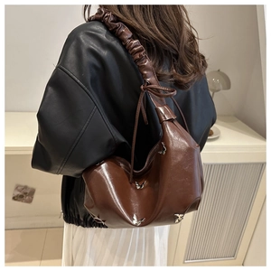 Gros plan sur un sac cabas marron rétro avec papillons métalliques et bandoulière froncée