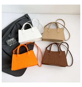 Close-up of crocodile pattern handbags in white, beige, orange, and brown with shoulder straps